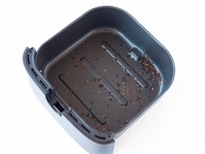 leftover food crumbs in an air fryer basket