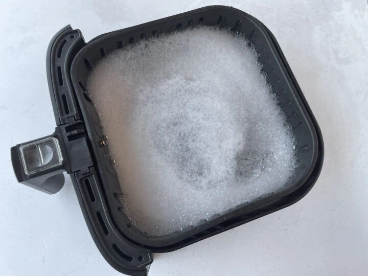 wash air fryer basket grease by adding soap and water