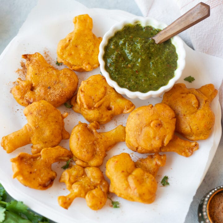 golden brown cauliflower pakora with green chutney on the side