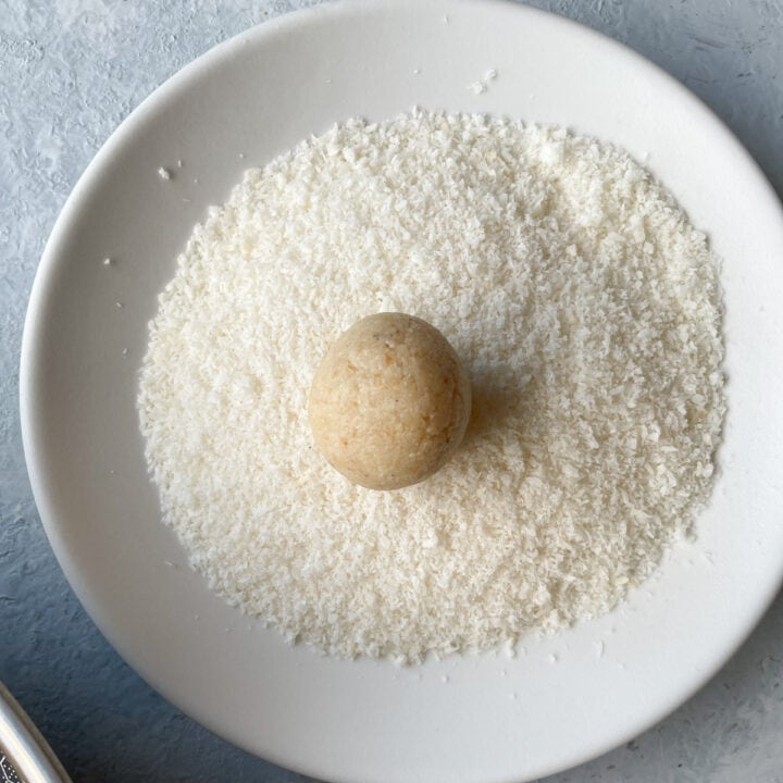 Almond Coconut Ladoo on a plate with desiccated coconut
