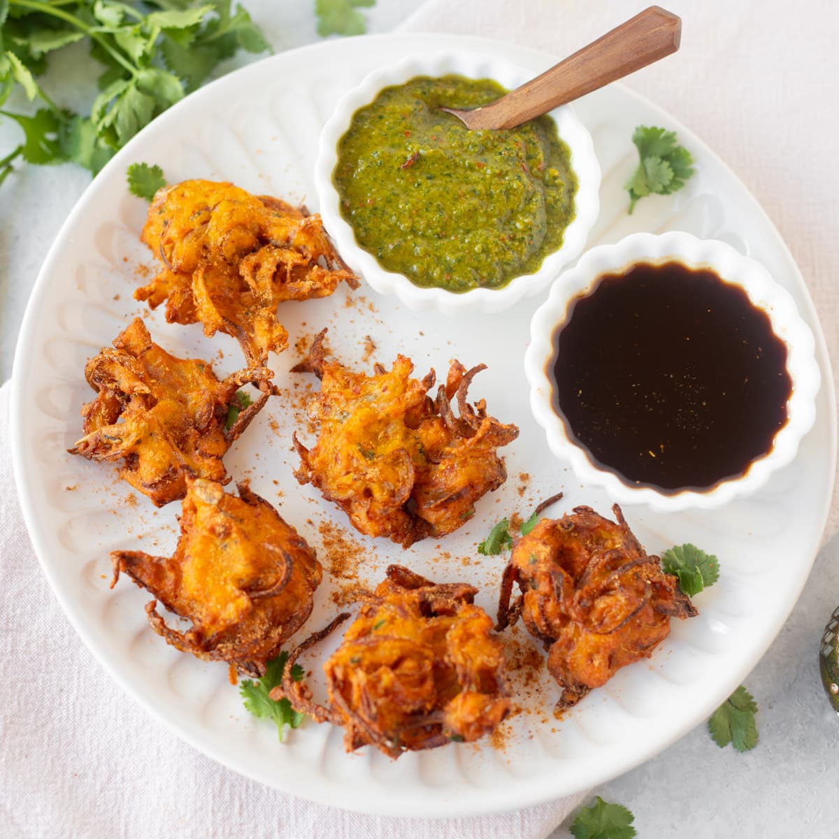 Kanda bhajiya garnished with chaat masala and cilantro