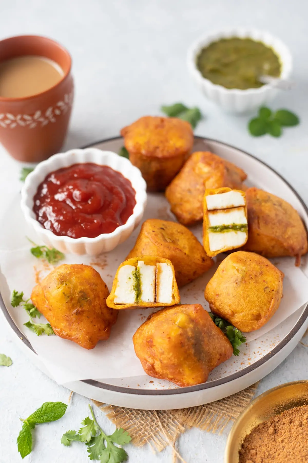 Paneer pakoras in a plate served with ketchup and chai