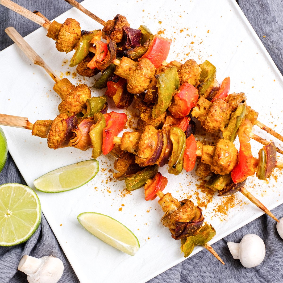 Mushroom tikka in a white plate garnished with chaat masala