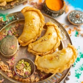 Gujiya made with Mawa/khoya in a plate with rose petals