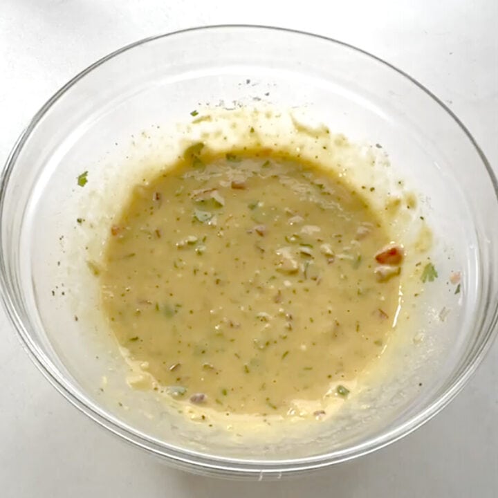 whisk besan batter in a glass bowl