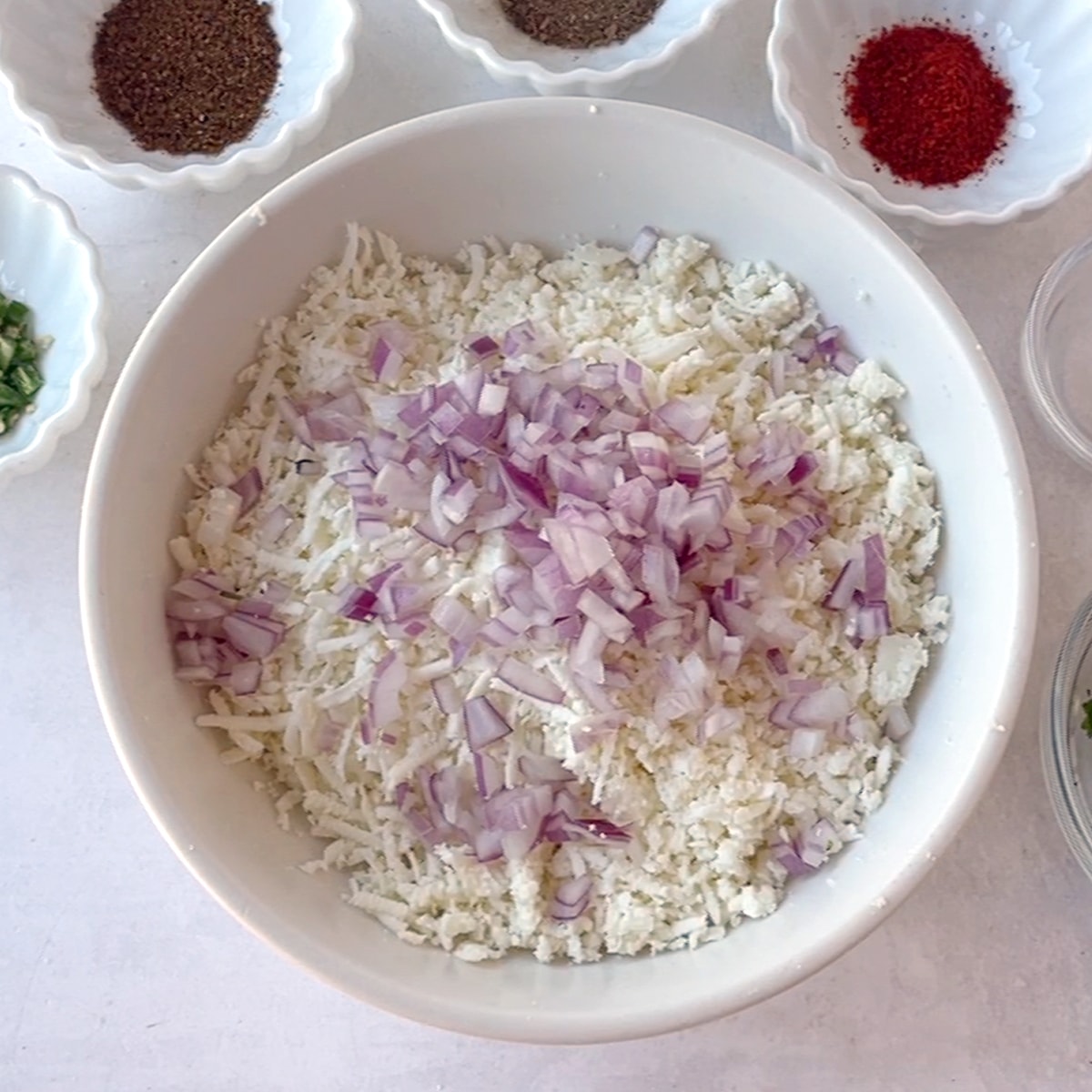 now add onion in the bowl of grated paneer