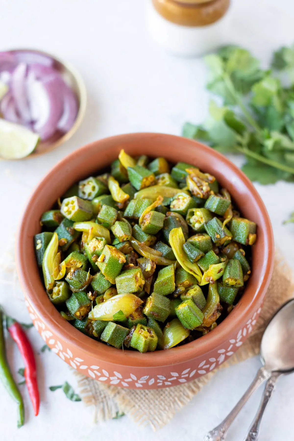 Bhindi do pyaza in a pot with cilantro on the side
