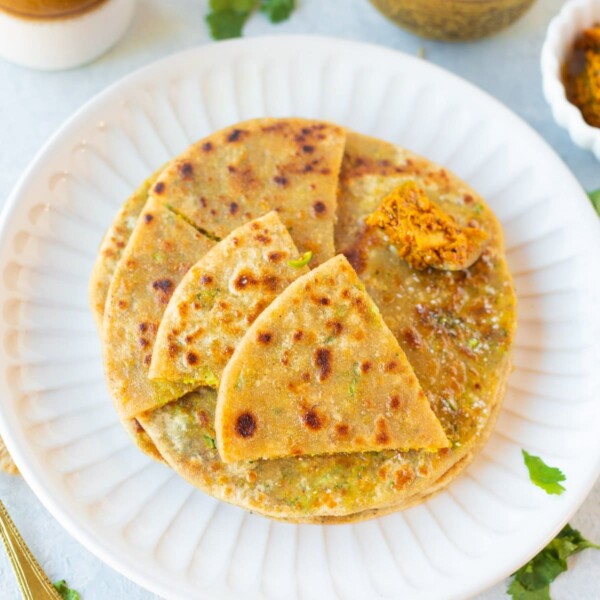 Broccoli paratha cut in triangles in a plate with pickle