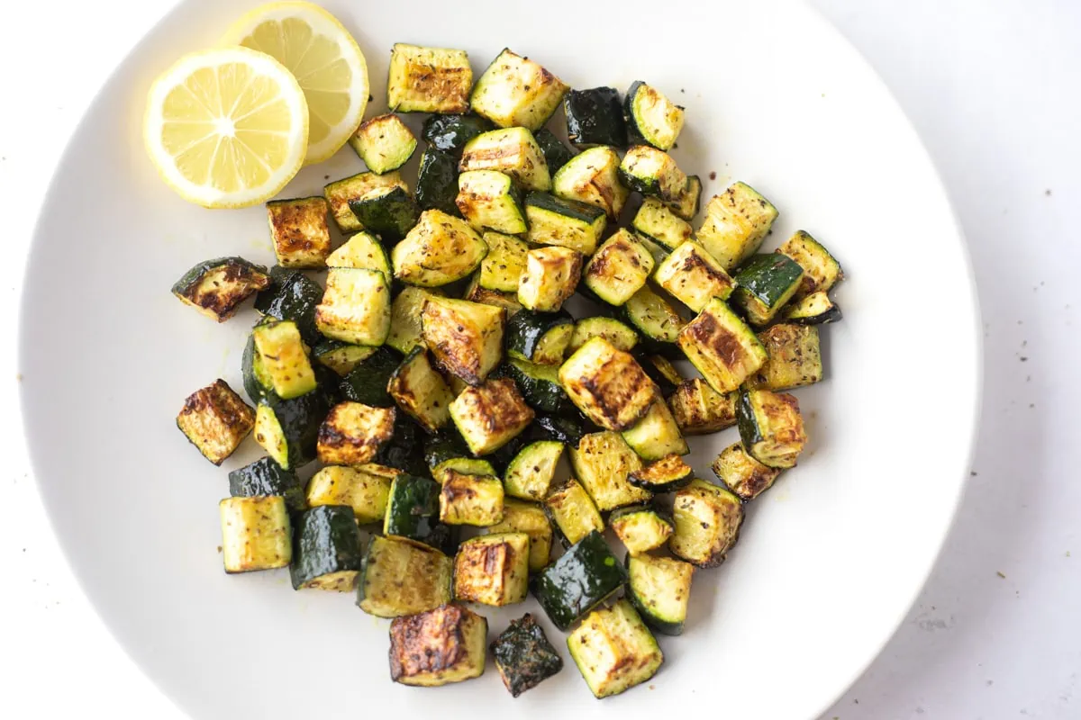 Air Fryer Zucchini in a plate with lemon slices