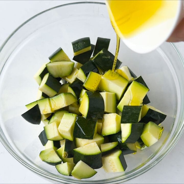 Add oil to the zucchini in a glass bowl