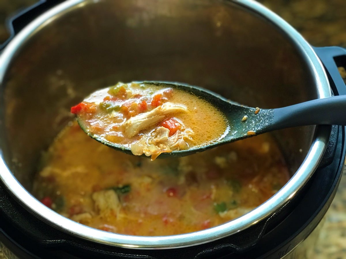 Chicken fajita soup in a ladle on top of the instant pot.