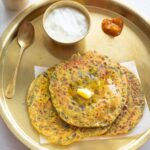 methi paratha in a brass plate with dahi