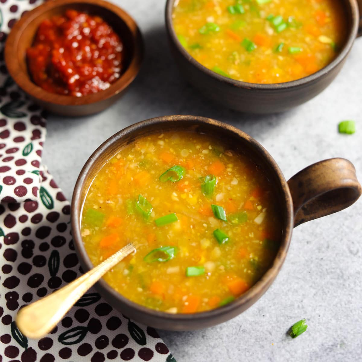 Sweet corn soup served in two bowls garnished with green onions.