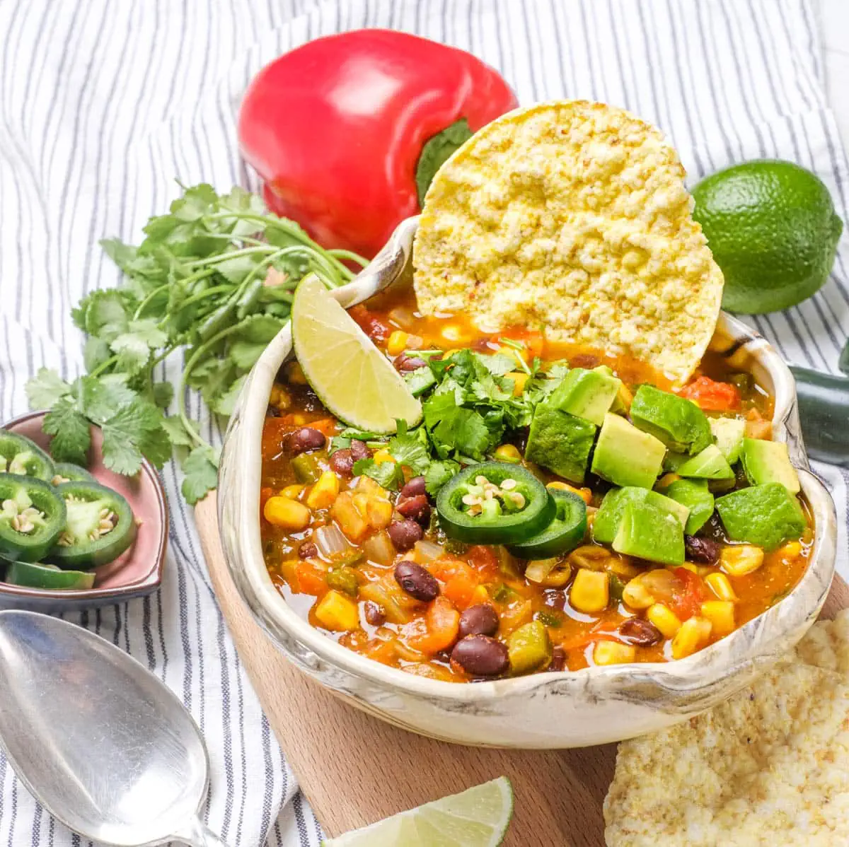 Delicious Vegetarian Taco Soup in a bowl topped with diced jalapeños and avocado. 