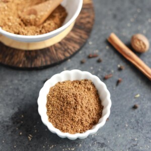 Authentic homemade garam masala in a small white bowl.