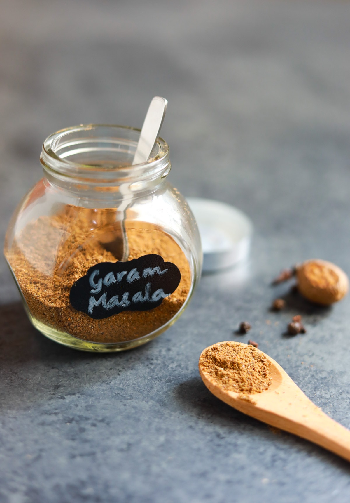 North Indian Garam masala in a glass jar and in a spoon.