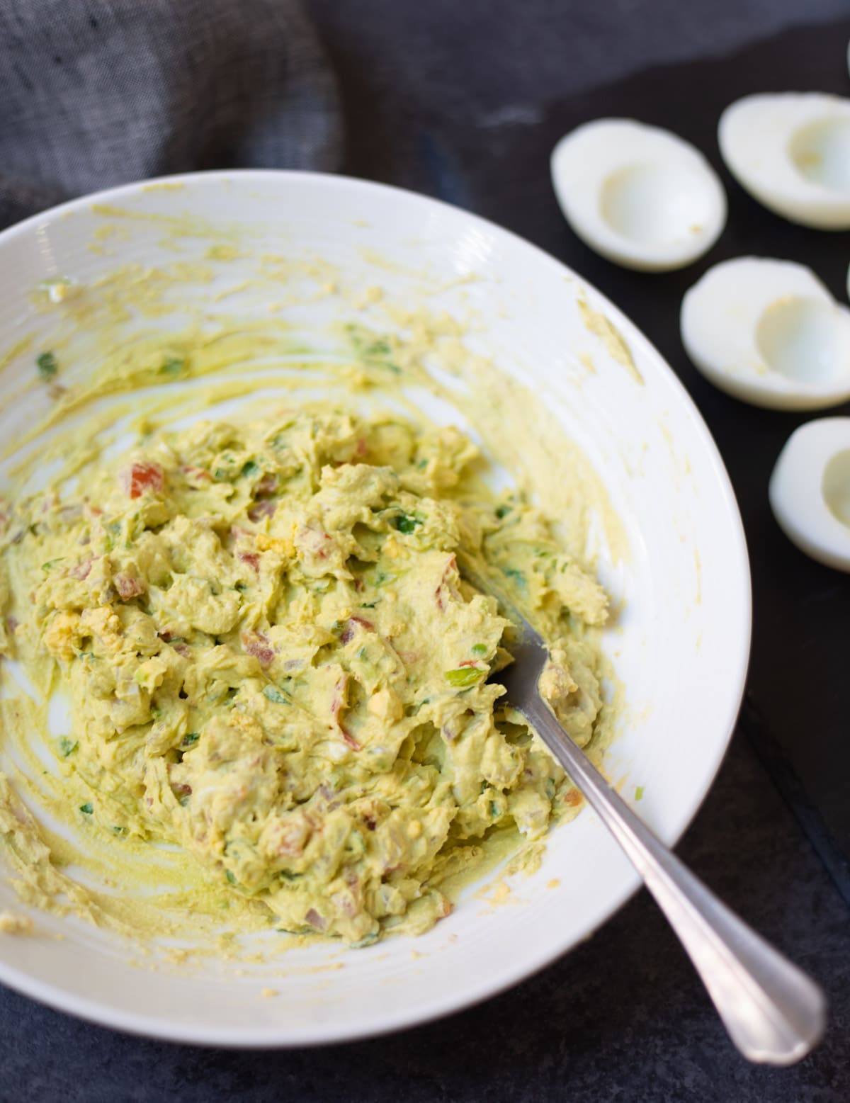 Filling for guacamole deviled eggs in a white bowl