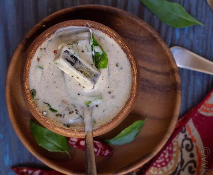 Okra raita in a wooden bowl with spoon