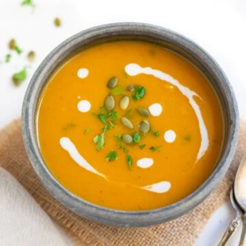 sweet potato soup in a bowl garnished with cilantro and cream.