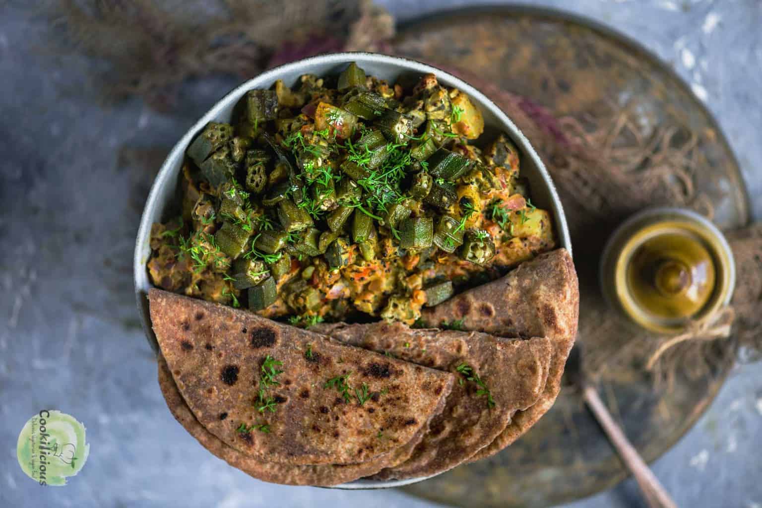 Achari Dahi Bhindi on a plate served with roti