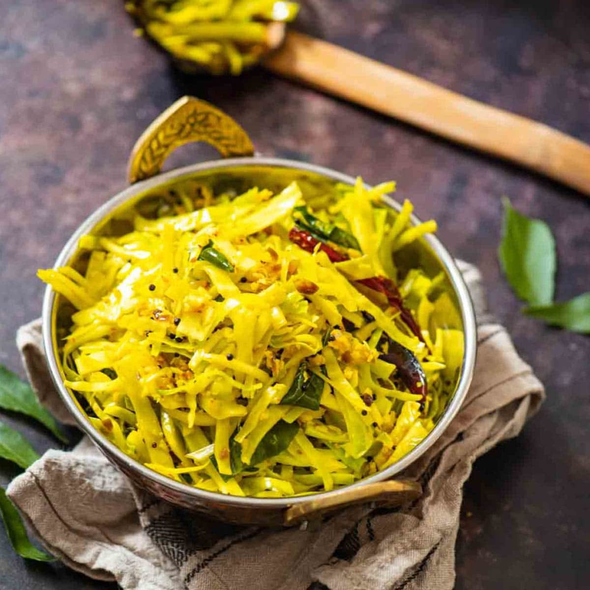 serving bowl with sauteed cabbage on a brown background