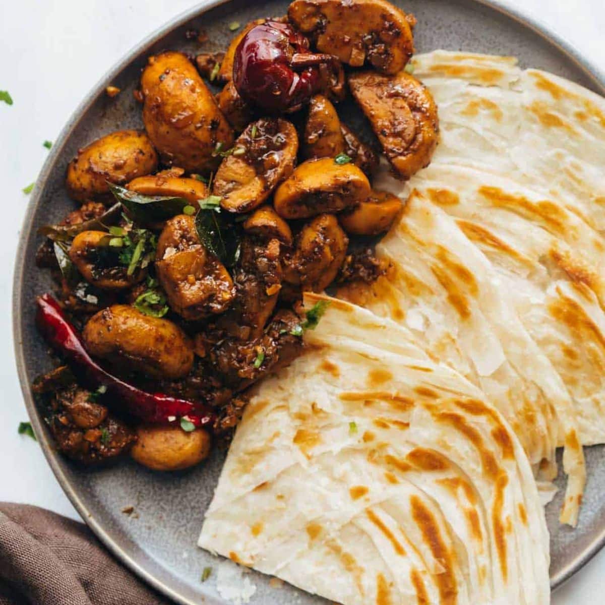 Mushroom pepper fry in a plate with paratha