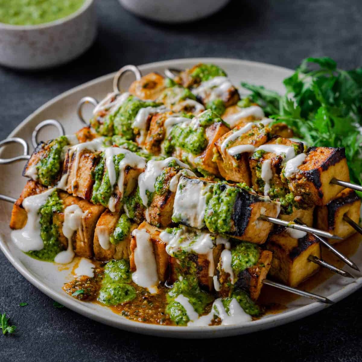 Grilled tofo skewers in a plate with sauce