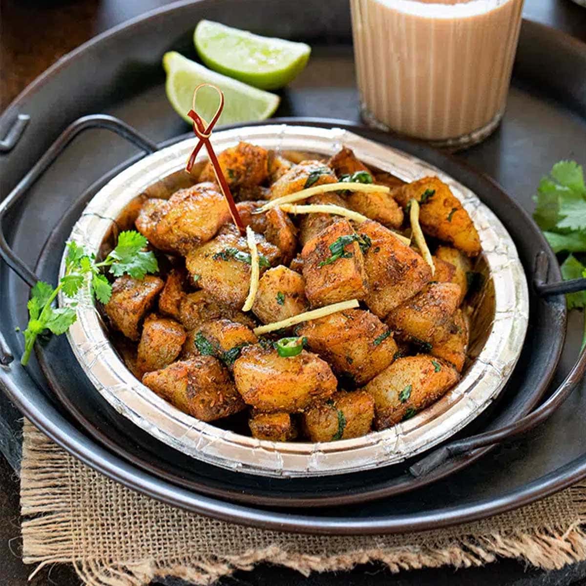 Delhi Aloo Chaat in a plate with lemon wedge