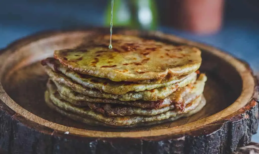 puran poli made with sweet potato in a plate topped with ghee
