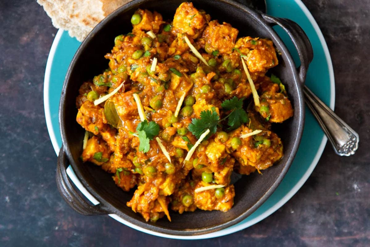 vegan matar tofu served in a small skillet with a side of flatbread 