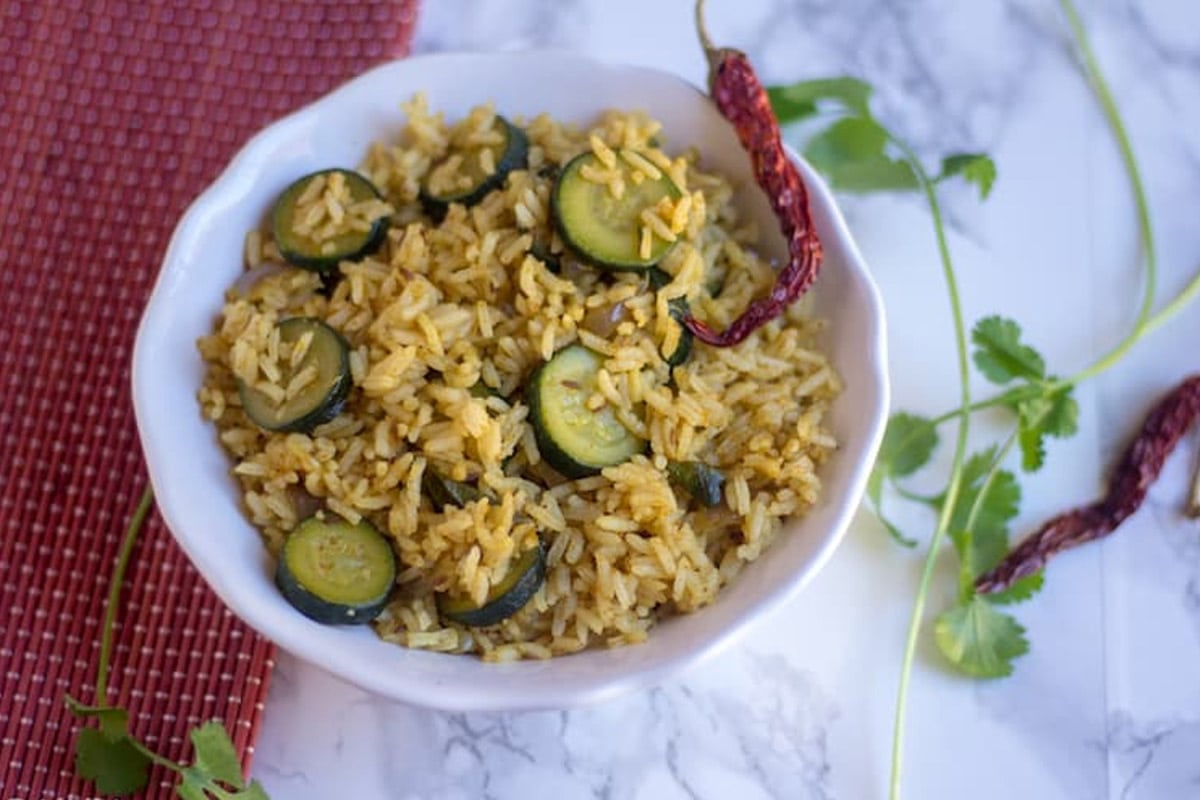 Zucchini rice in a bowl with red chili pepper on top