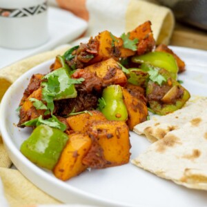 Tasty and colorful Aloo Simla Mirch garnished with cilantro