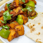Deliciously cooked Stir fry Potato Simla Mirch in a white plate