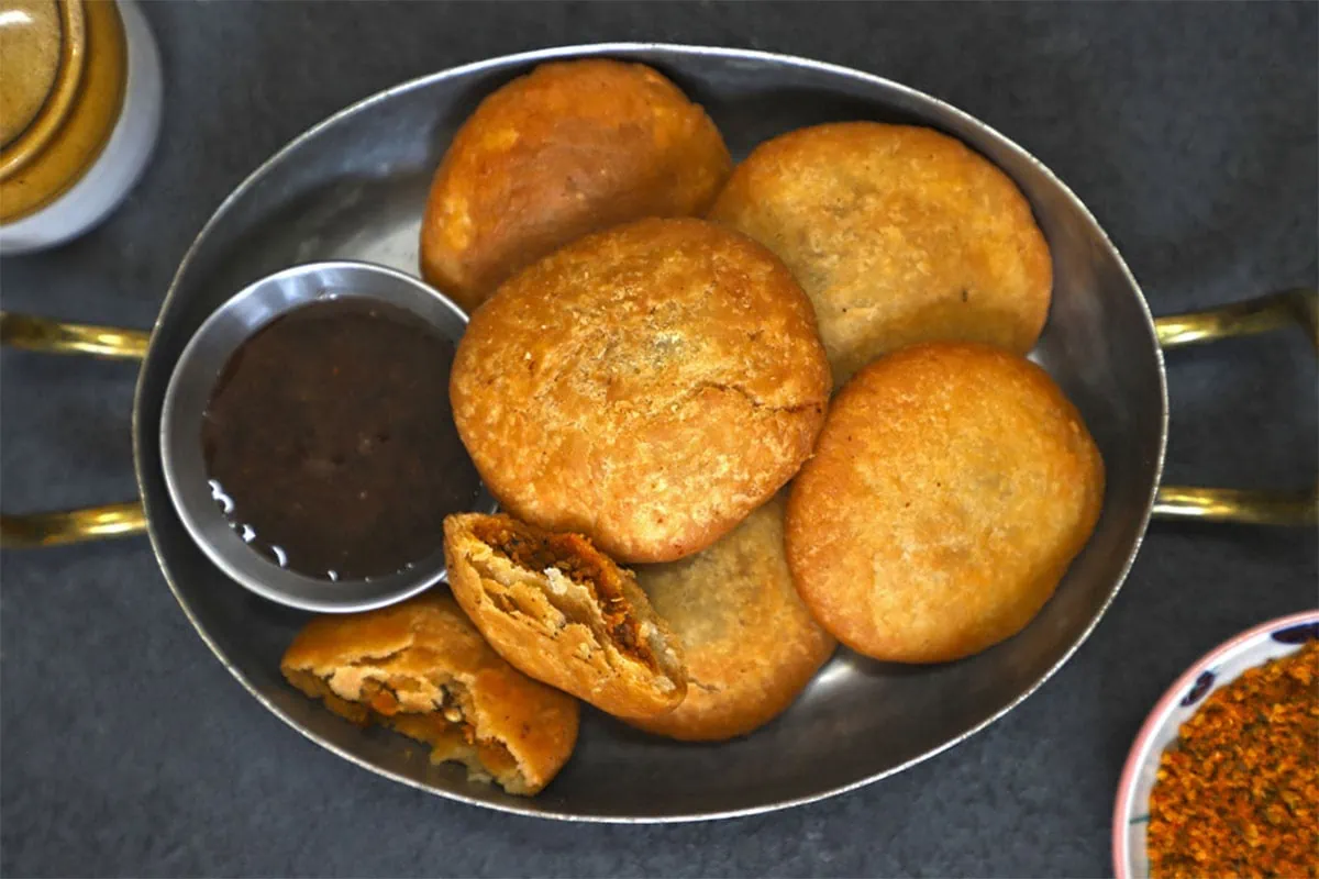 aerial shot of kachori stacked up in a brass platter