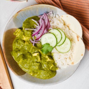 Creamy Palak Tofu in a white bowl with rice and garnished with coriander