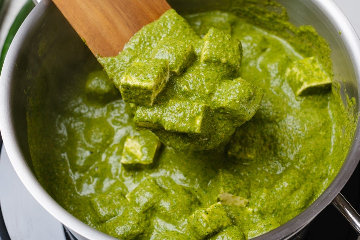 Tofu Palak Paneer with spinach, onion, and tomato gravy in a pan