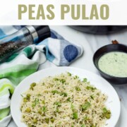 A flavorful and fragrant rice dish filled with green peas, and whole spices, and topped with chopped cilantro.