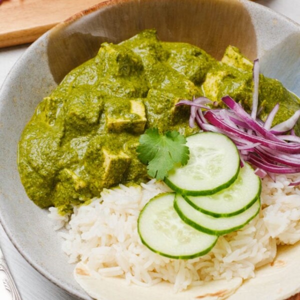 Aromatic Palak Tofu curry with a side of rice and onion