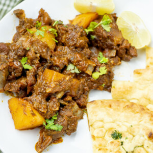 Pakistani Aloo Gosht recipe with lemon slide on the side