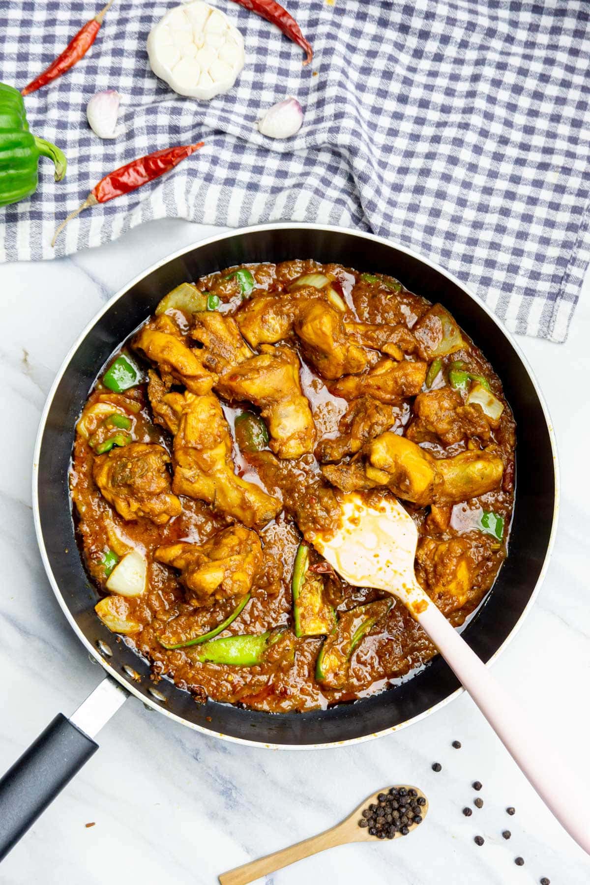 Kadai Chicken with spatula in a pan