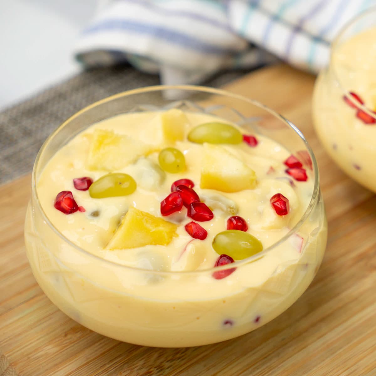 Fruit custard with banana, mango, grapes and pomegranates in a bowl