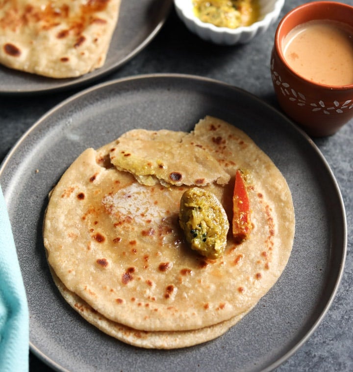 Paratha, pan fried indian flatbread along with pickle and chai
