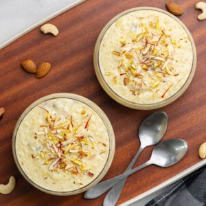 Sabudana kheer in two bowls garnished with saffron and nuts.