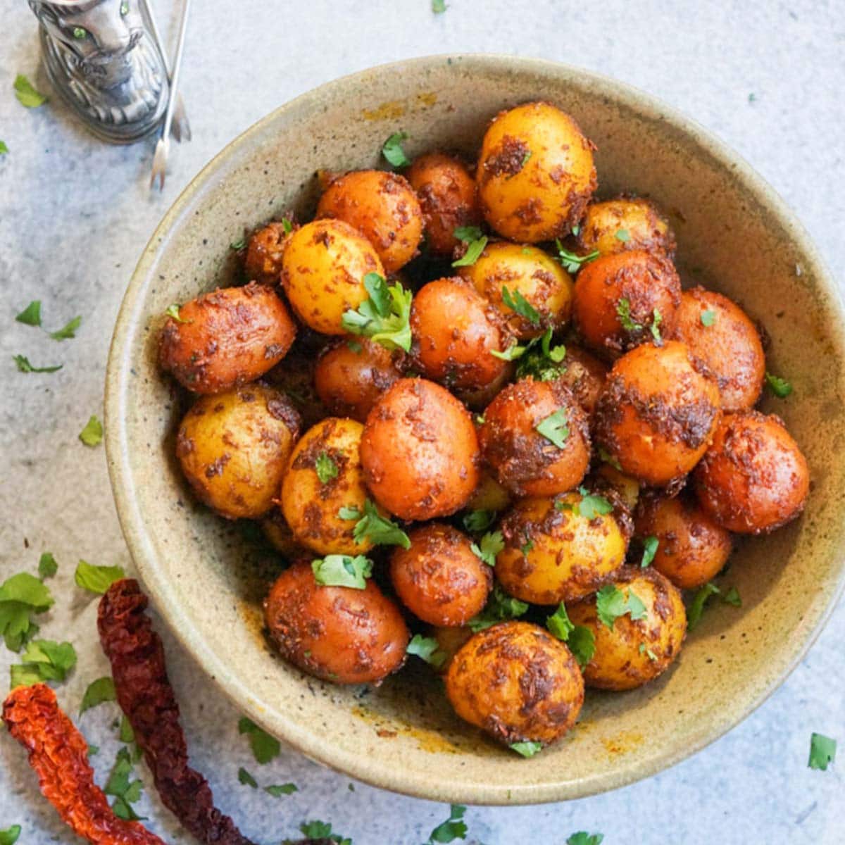 Spicy bombay potatoes in a brown bowl