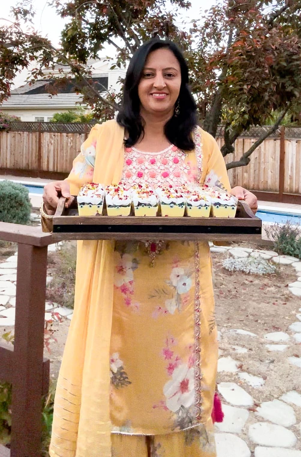 Meeta taking a tray of mini custard trifle cups for a party