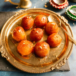 Gulab Jamun (Indian sweet balls) served in a pretty brass plate.