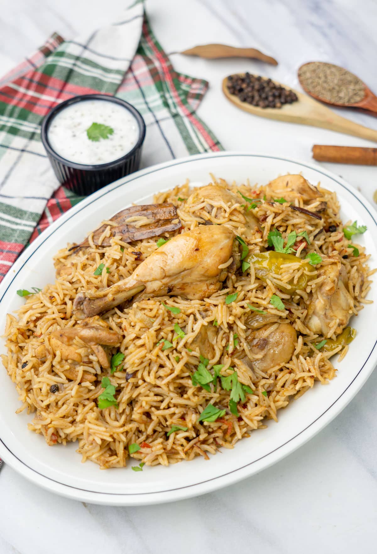 Indian Chicken Rice garnished with cilantro with raita