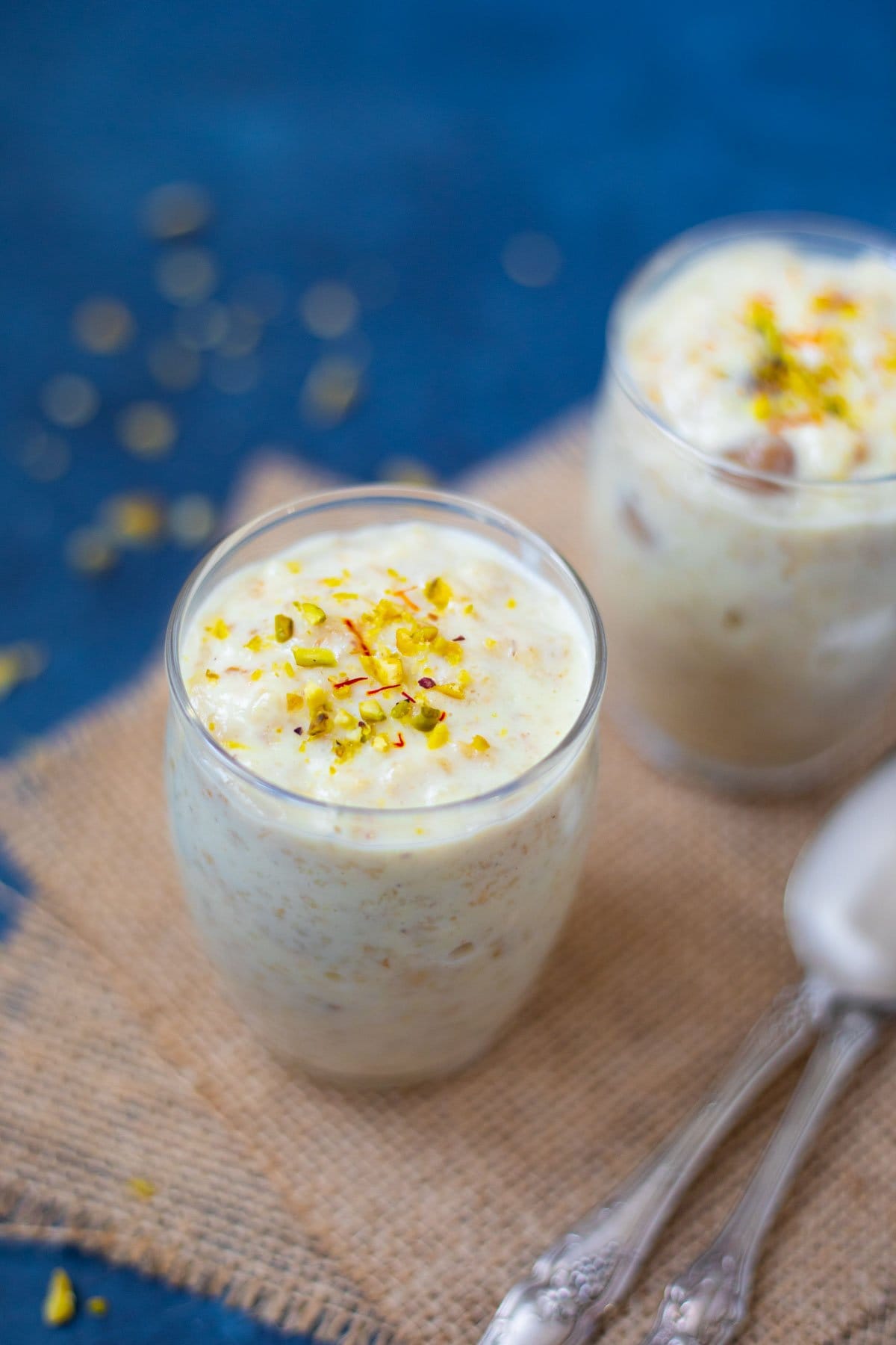 Sweet Oatmeal (Oats Kheer) served in cups garnished with pistachops and saffron.