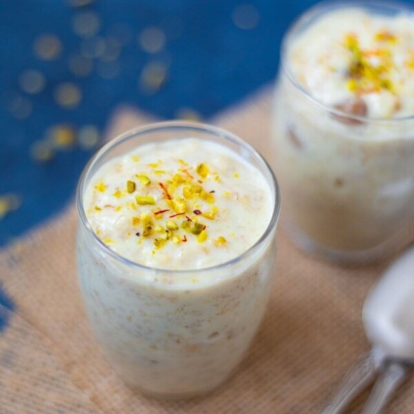Sweet Oatmeal (Oats Kheer) served in cups garnished with pistachops and saffron.