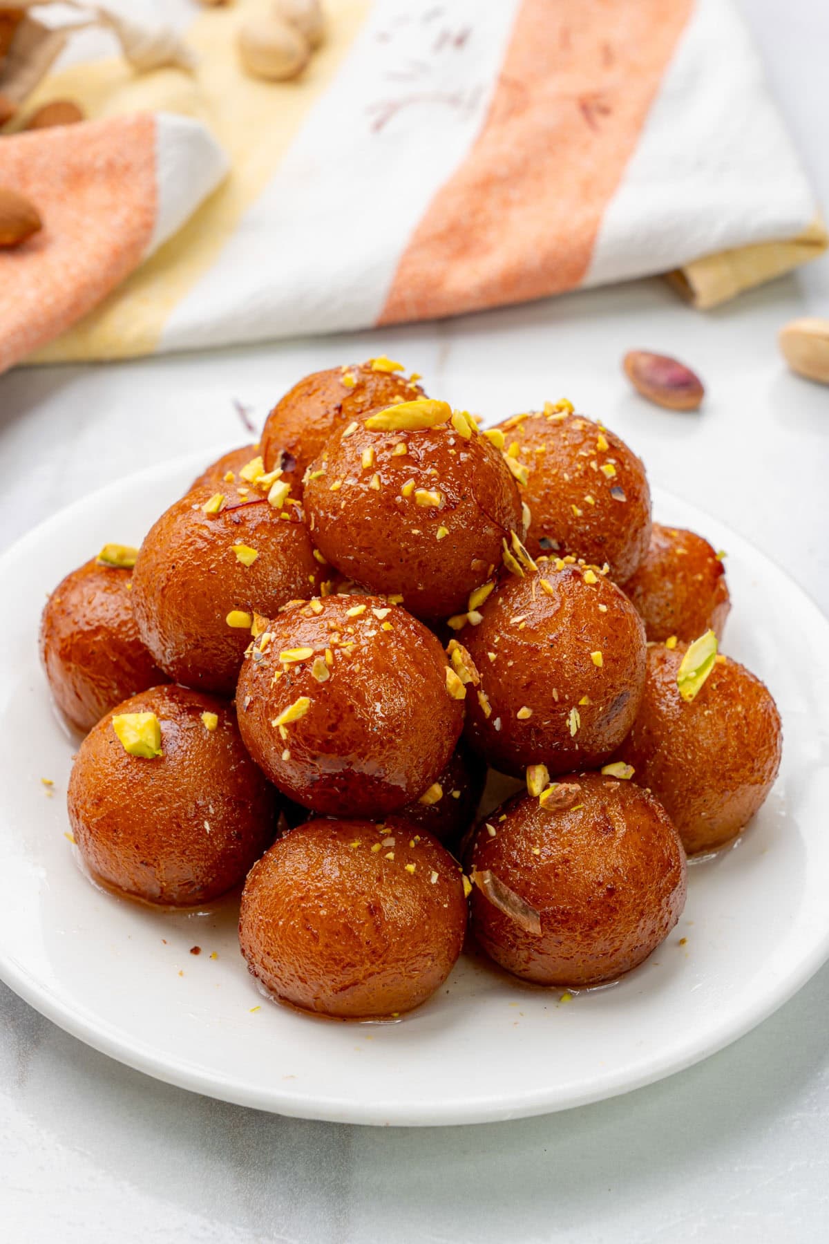 Gulab Jamun served in a plate garnished with nuts